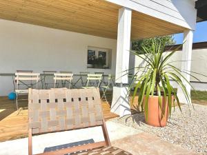 a patio with a chair and a potted plant at Villa luxueuse avec piscine chauffée in Gujan-Mestras