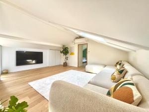 a living room with a couch and a flat screen tv at Villa luxueuse avec piscine chauffée in Gujan-Mestras