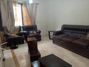 a living room with a leather couch and chairs at Luxury Corner Cottage Guest House on Main Road G11 in Islamabad