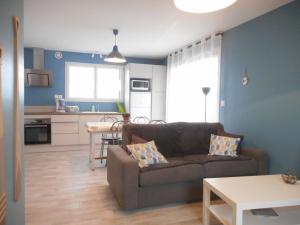a living room with a couch and a kitchen at Le Ptit Zef in Pluduno