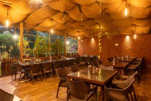 a restaurant with tables and chairs in a tent at Dandeli Wild River Resort in Dandeli