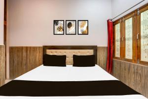 a bedroom with a large bed with three pictures on the wall at Hotel O GOLD PLAZA HOME STAY in Chandausi +21 photos