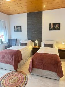 a bedroom with two beds and a blue chair at Mahesars Home 2 in Ennepetal