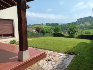 a porch of a house with a grass yard at Casa Rural Collado 