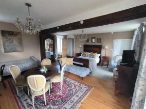 a living room with a bed and a table and chairs at Le Presbytere in Beauficel