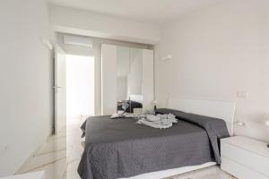 a white bedroom with a bed and a mirror at Casa Moniga 2-Residenze Lizzeri in Moniga