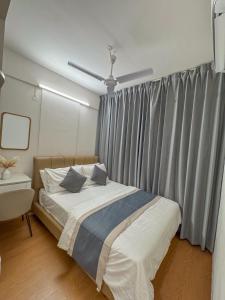 a bedroom with a bed and a window with curtains at Lux Stay in Hulhumale