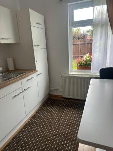 巴亚马雷Casa Blanka的厨房配有白色橱柜和窗户。