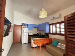cocina con armarios azules, sofá y mesa en Casa Aloha, en São Miguel do Gostoso 24 fotos más