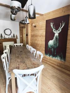 une salle à manger avec une table et une peinture de cerfs sur le mur dans l'établissement Gîte de Charme nature, calme, randonnée et air pur, à Le Valtin