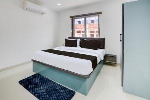 a bedroom with a bed and a mirror at Hotel O Viraj Luxury Stay in Warangal