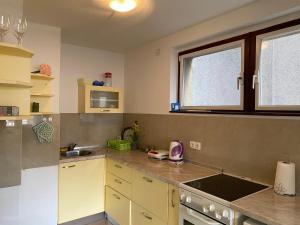 a kitchen with yellow cabinets and a sink and a window at Sunshine Apartments Visoko in Visoko