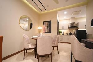 a kitchen and dining room with a table and chairs at Luxury 1BR Designer Condo at Zeta Mall Islamabad Balcony, Parking & Steps from Giga Mall in Islamabad