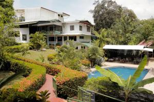 a large house with a swimming pool in front of it at Hotel Divisamar by LHR in Manuel Antonio