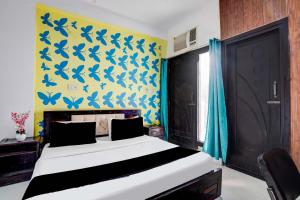 ニューデリーにあるHotel O Singhのベッドルーム1室(青い蝶が壁に描かれたベッド1台付)