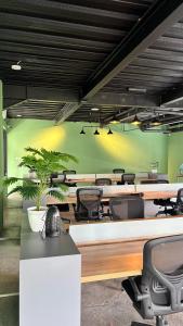 an office with desks and chairs and a green wall at Alzeto Coliving in Legian