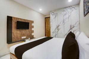 Un dormitorio con una cama y un televisor en una pared. en Hotel O Amazing House, en Nueva Delhi 26 fotos más