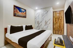 Un dormitorio con una cama grande y una pared. en Hotel O Amazing House, en Nueva Delhi
