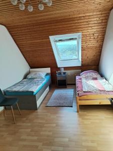 a attic bedroom with two beds and a window at Ferienwohnung Elena 2 in Zweibrücken