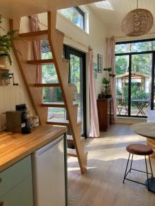 a kitchen with a wooden staircase in a house at Cozy Tiny House in the forest with spacious private garden in Zuidwolde +14 photos