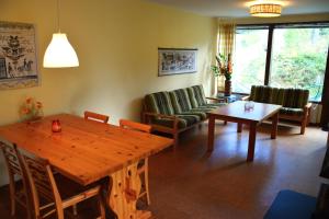 a living room with a wooden table and chairs at Ekesberget Stugby stuga 15 in Ekshärad