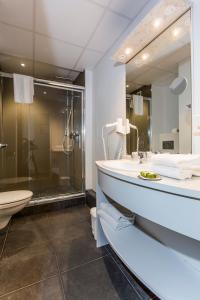 La salle de bains est pourvue d'une baignoire, d'un lavabo et d'une douche. dans l'établissement Logis Hôtel Le Relais, à Biscarrosse