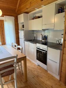 a kitchen with white appliances and a wooden table at Paritalomökki Pytkynharjussa in Syöte +8 photos