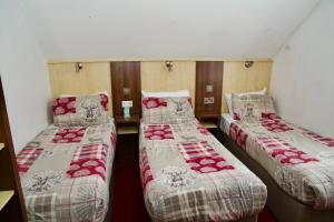 a room with three beds in a room at The Gatwick White House Hotel in Horley