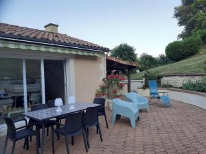 a patio with a table and chairs on a patio at Détente au bord de la rivière in Bonnes +5 photos