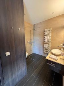 a bathroom with a shower and a toilet and a sink at Boutique & Wellnesshotel Thalmässing in Thalmässing +17 photos