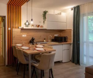 a kitchen with a wooden table and chairs in a room at Stay & Spa Central in Sfântu-Gheorghe