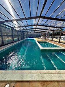 a large swimming pool with a roof over it at Pousada Village Garopaba in Garopaba