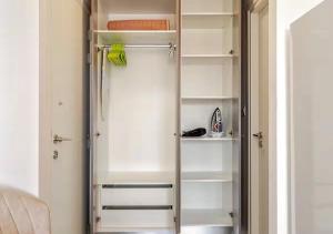 a closet with white doors and shelves in a room at Urban Bay Limassol in Limassol