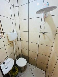 a small bathroom with a toilet and a sink at Pousada DL in Pelotas
