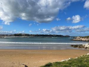 a beach with the ocean on a cloudy day at Apartamento Camino a Lancha in Miengo