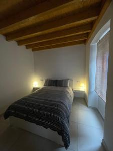 a bedroom with a bed with two lights on it at La Casa De La Arena in San Juan de la Arena +19 photos