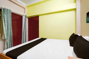 a bedroom with a bed and a red door at Hotel O Rudraksha in Khagaul