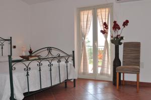 a bedroom with a bed and a chair and a vase with flowers at Villa Lidia in Paola