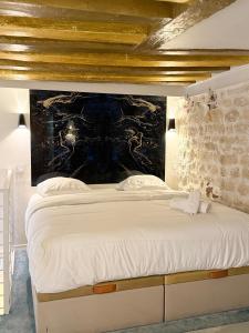 パリにあるIle saint Louis Notre Dame de Parisのベッドルーム1室(壁に白い大型ベッド1台付)