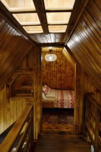 a small room with a bed in a wooden house at Ranč Kuzmanović in Doboj +27 photos
