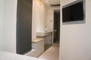 a bedroom with a tv on a wall at Homy Central in Hong Kong