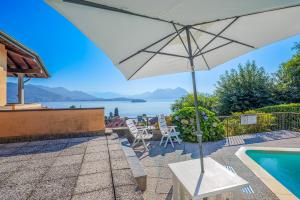 a patio with an umbrella and a swimming pool at Residenz Vogino in Baveno
