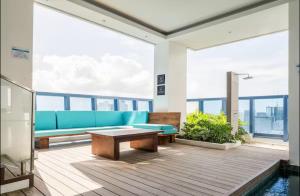 ein Wohnzimmer mit einem blauen Sofa und einem Tisch in der Unterkunft City Garden Inside IT Park Gym & Pool Fast Wi-Fi in Cebu City