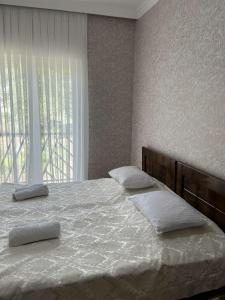 a bedroom with a large bed with two pillows on it at Guest House Tobuldar in Kʼveda Marghi