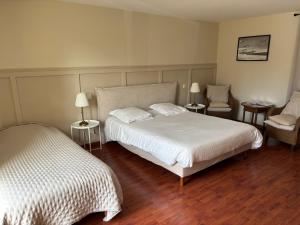 a bedroom with a bed and a chair and two beds at Chambre Victory in Colleville-sur-Mer