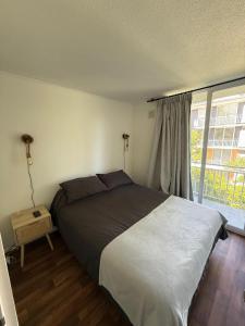 a bedroom with a large bed and a window at Departamento familiar en Pucón in Pucón +23 photos