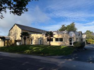 a large stone building with palm trees in front of it at Chambre Victory in Colleville-sur-Mer