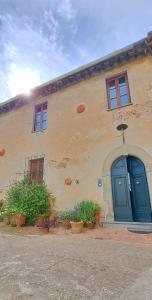 a building with blue doors and plants in front of it at Il casale dei tigli in Limite