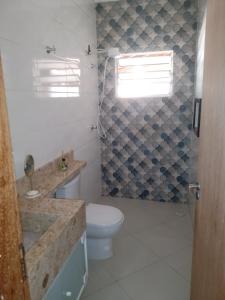 a bathroom with a toilet and a sink and a window at Chácara da Nina - Itatiba in Itatiba +16 photos