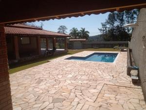 a patio with a swimming pool and a house at Chácara da Nina - Itatiba in Itatiba